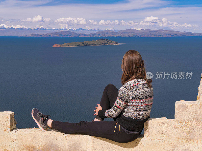 年轻女子的肖像坐在美丽的风景上的太阳岛，isla del sol，秘鲁